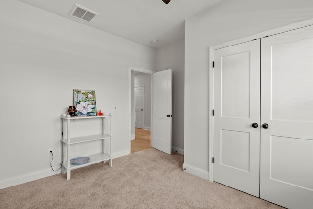 carpeted bedroom with baseboards and a closet
