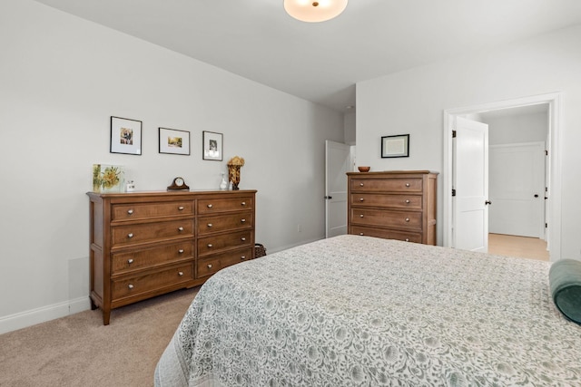 bedroom featuring light colored carpet and baseboards