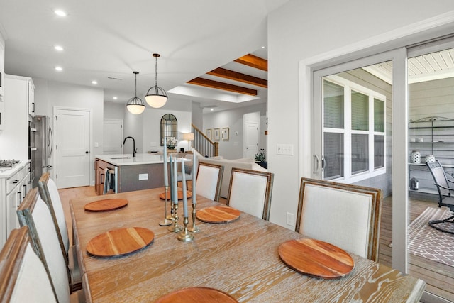 dining space featuring stairs, recessed lighting, light wood finished floors, beverage cooler, and beamed ceiling