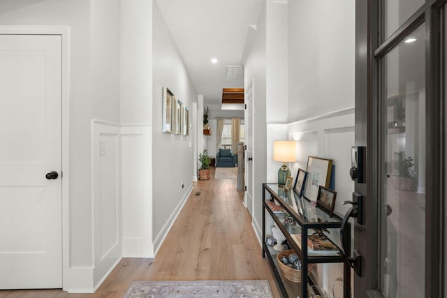 hallway featuring light wood-style flooring, recessed lighting, and baseboards
