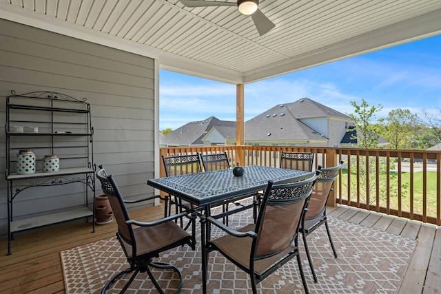 wooden deck with outdoor dining area and a ceiling fan