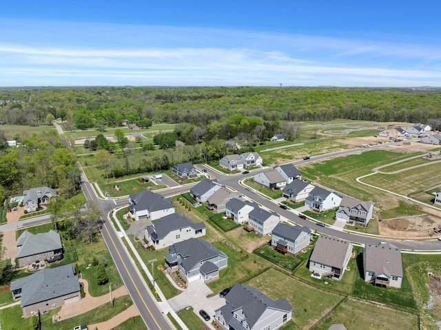 aerial view of property's location featuring a heavily wooded area and nearby suburban area