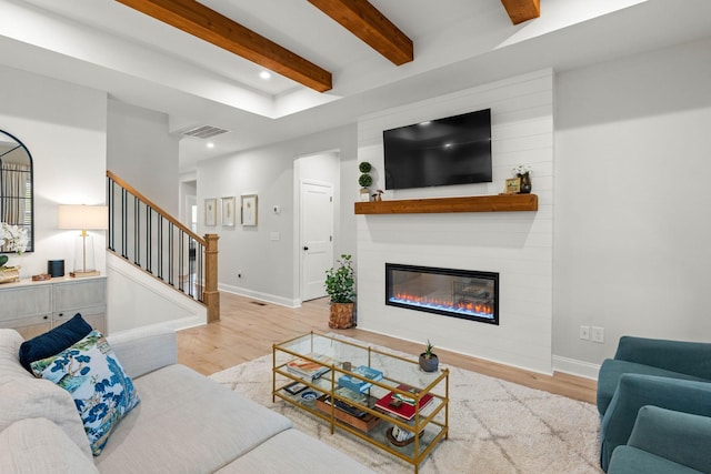 living room with wood finished floors, beamed ceiling, stairs, recessed lighting, and a fireplace
