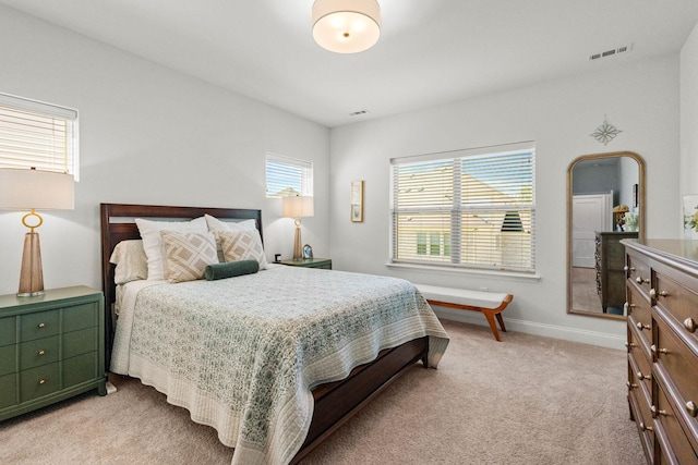 bedroom with light colored carpet and baseboards