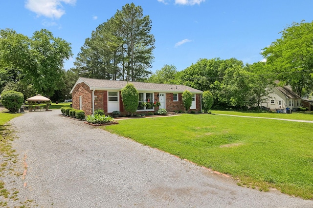 single story home with a front lawn, brick siding, driveway, and a gazebo