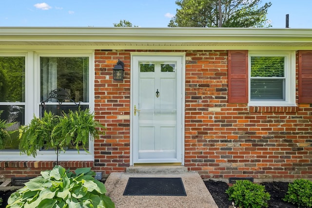 doorway to property featuring brick siding