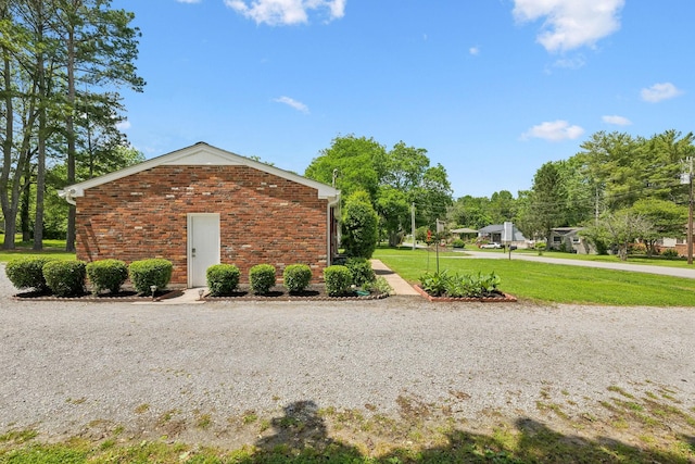 view of side of property with brick siding and a yard