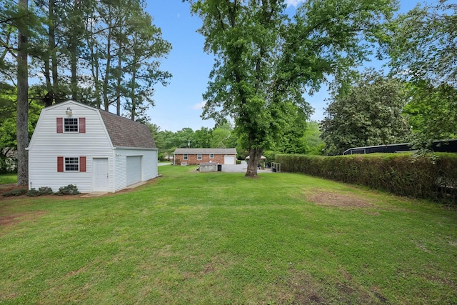 view of green lawn featuring a garage, an outdoor structure, and view of wooded area