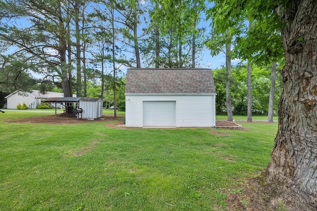 view of green lawn with an outdoor structure, a storage shed, and a garage
