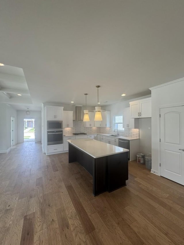 6709 Major Hutchings Dr, Hermitage, TN 37076 - kitchen with appliances with stainless steel finishes, wood finished floors, wall chimney exhaust hood, a center island, and recessed lighting