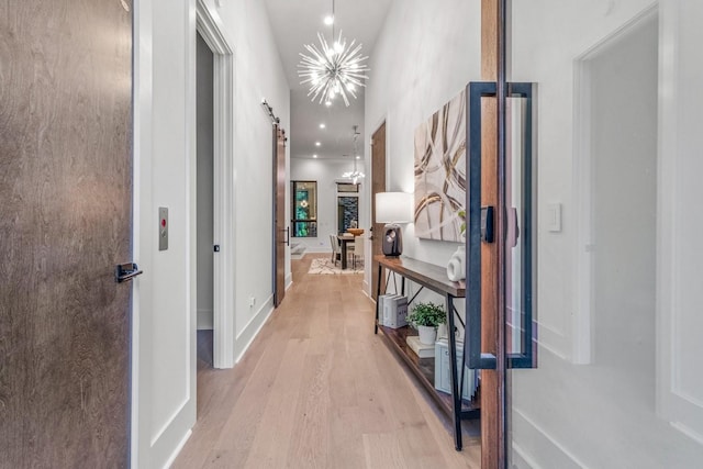 4303A Utah Ave, Nashville, TN 37209 - hall featuring light wood-style flooring, a barn door, and baseboards