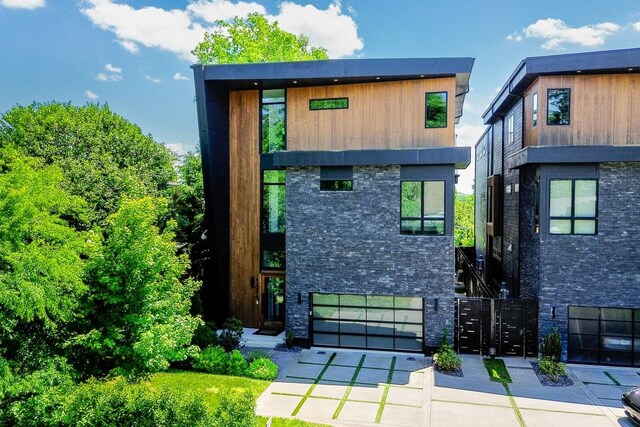4303A Utah Ave, Nashville, TN 37209 - view of front of house with concrete driveway, an attached garage, and stone siding