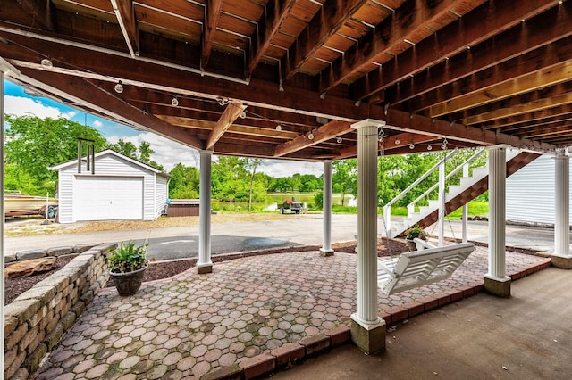 view of patio with an outdoor structure, stairway, and a garage