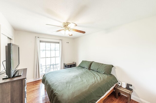 bedroom featuring light wood-style floors, baseboards, and ceiling fan