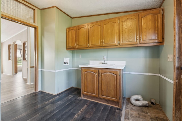 laundry area featuring cabinet space, dark wood-style flooring, washer hookup, ornamental molding, and baseboards