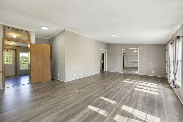 unfurnished living room featuring ornamental molding, dark wood-style flooring, baseboards, and recessed lighting
