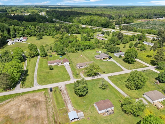 aerial view of property and surrounding area featuring a heavily wooded area