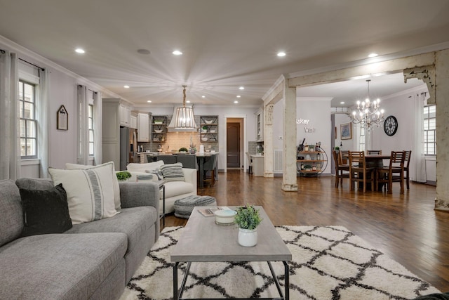 living room featuring a chandelier, crown molding, dark wood-style floors, and recessed lighting