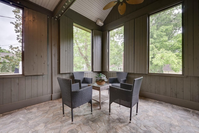 sunroom with stone flooring, vaulted ceiling, wood walls, and wood ceiling