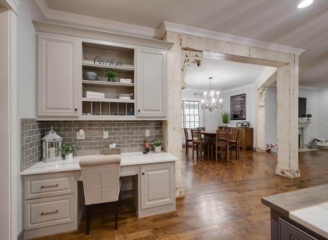office featuring crown molding, built in study area, dark wood finished floors, and a chandelier