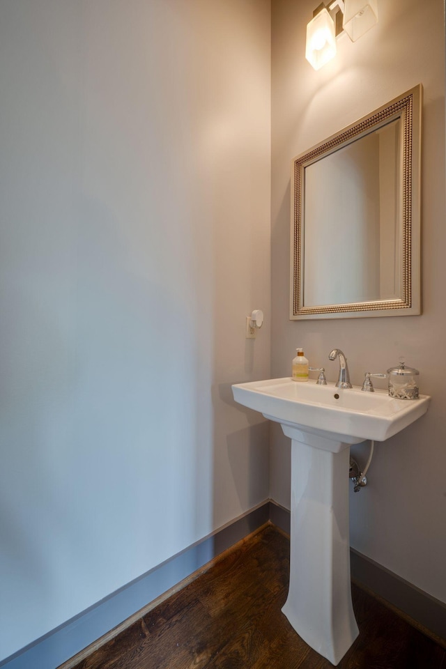 bathroom with wood finished floors and baseboards