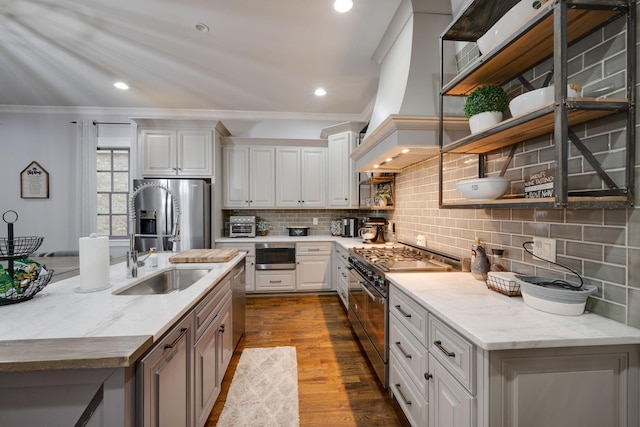 kitchen featuring open shelves, appliances with stainless steel finishes, crown molding, a sink, and decorative backsplash