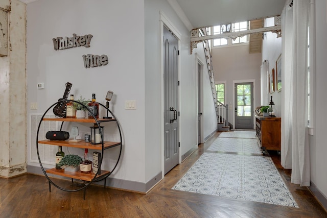 hall featuring plenty of natural light, baseboards, wood finished floors, and stairway