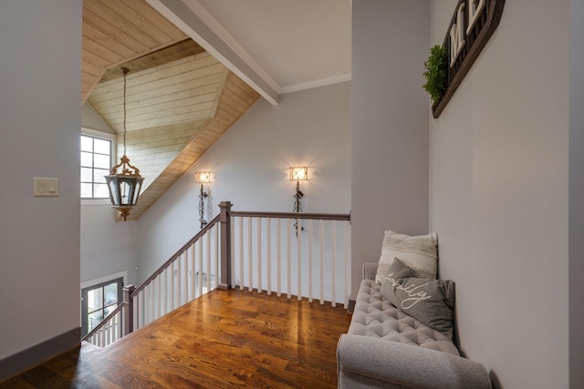 living area with an upstairs landing, wood finished floors, and wood ceiling