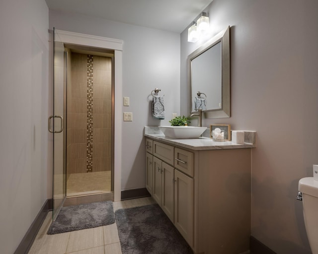 bathroom with a stall shower, vanity, toilet, and baseboards