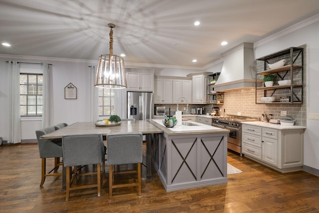 kitchen featuring stainless steel appliances, open shelves, backsplash, a kitchen island with sink, and recessed lighting