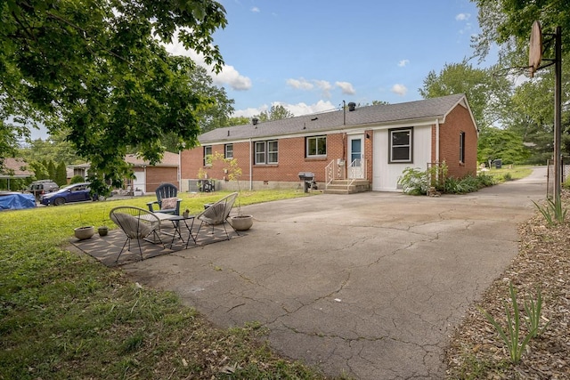 2413 Dundee Ln, Nashville, TN 37214 - back of house with a lawn, brick siding, and a patio
