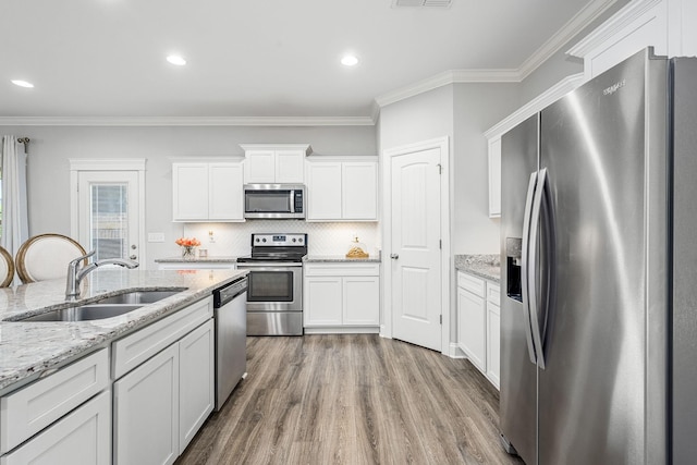 1006 Brinxton Run, Murfreesboro, TN 37128 - kitchen with appliances with stainless steel finishes, a sink, crown molding, wood finished floors, and white cabinets