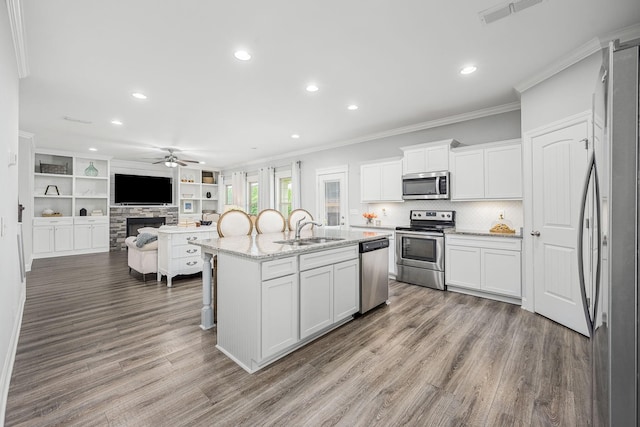 1006 Brinxton Run, Murfreesboro, TN 37128 - kitchen with stainless steel appliances, a sink, a ceiling fan, crown molding, and a stone fireplace
