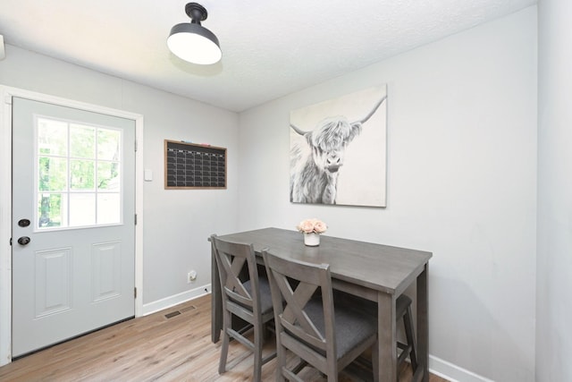 dining room with baseboards and light wood-style flooring