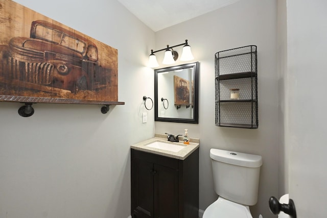 half bathroom featuring toilet, vanity, and baseboards