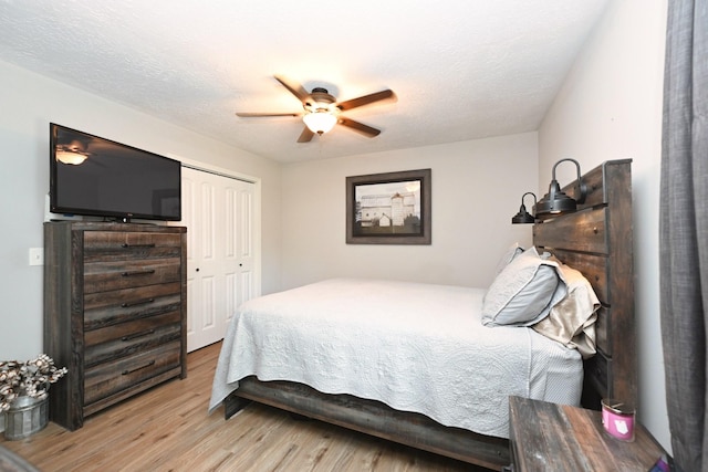 bedroom with wood finished floors, a closet, and a ceiling fan