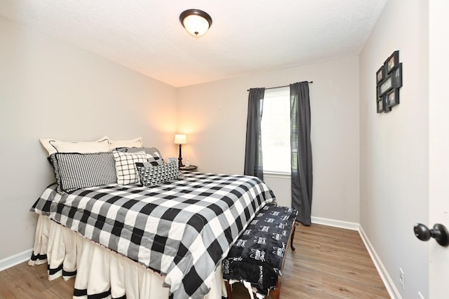bedroom with wood finished floors and baseboards