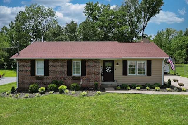 single story home with a front lawn, a chimney, and brick siding