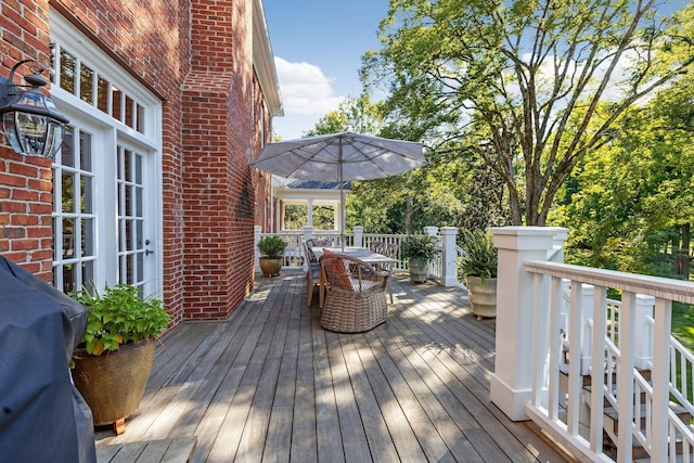 deck featuring outdoor dining space and grilling area
