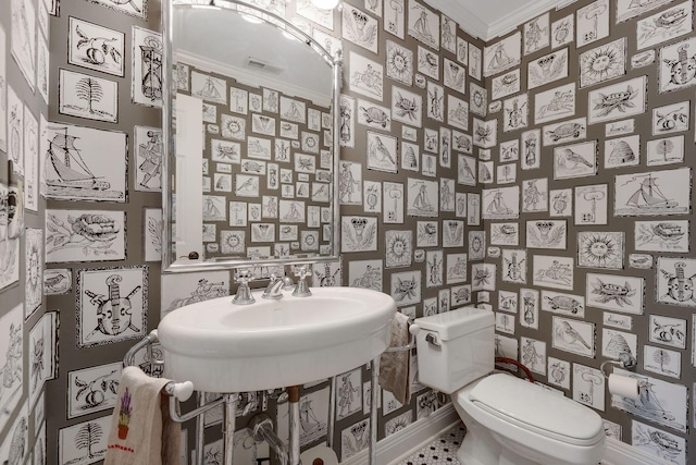 half bathroom featuring crown molding and toilet