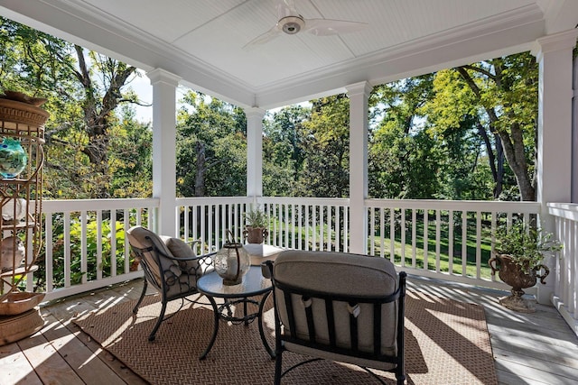 view of patio with ceiling fan and view of scattered trees