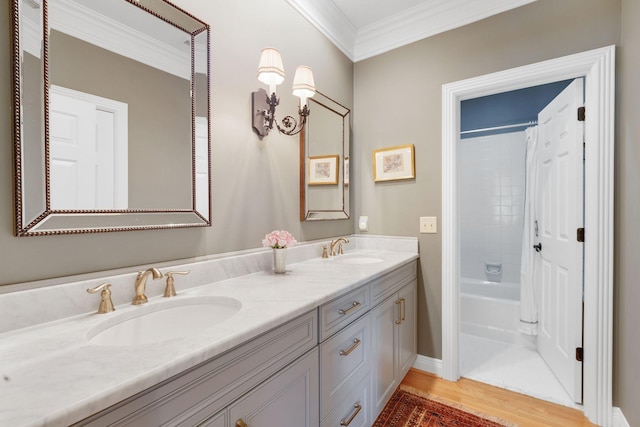 bathroom with crown molding, double vanity, wood finished floors, shower / bath combo, and baseboards