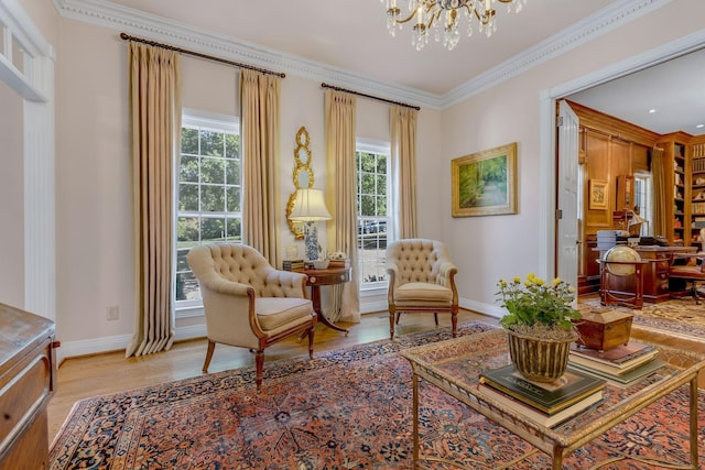 sitting room featuring light wood-type flooring, a chandelier, baseboards, and ornamental molding