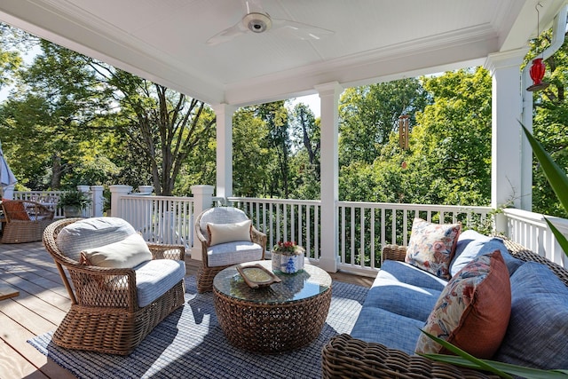 deck with an outdoor living space, ceiling fan, and view of scattered trees