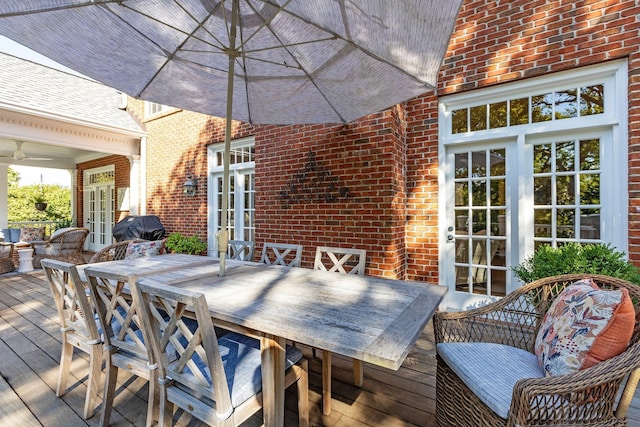 wooden deck featuring french doors, outdoor dining space, and grilling area