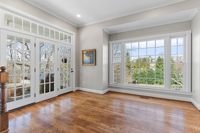entryway featuring baseboards, wood finished floors, crown molding, and recessed lighting