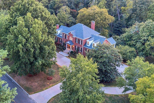 aerial view of property and surrounding area featuring a forest