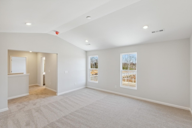 unfurnished room with lofted ceiling, light colored carpet, and baseboards