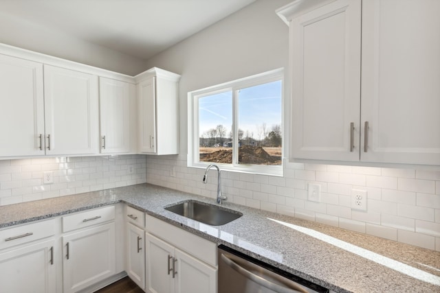 kitchen featuring a sink, stainless steel dishwasher, white cabinets, and backsplash