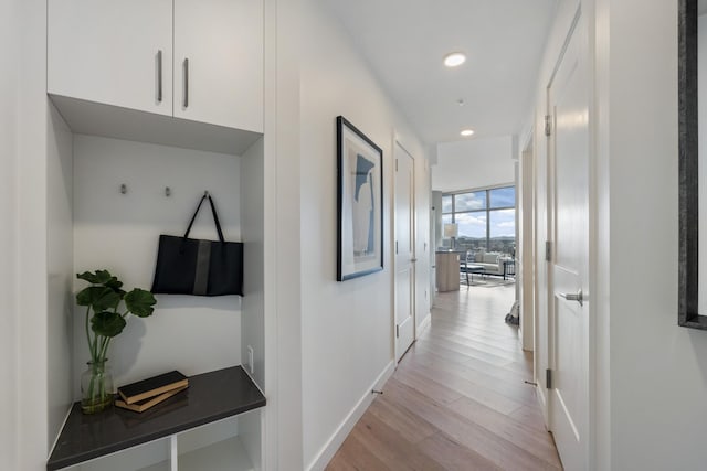 corridor featuring light wood-style floors, recessed lighting, and baseboards